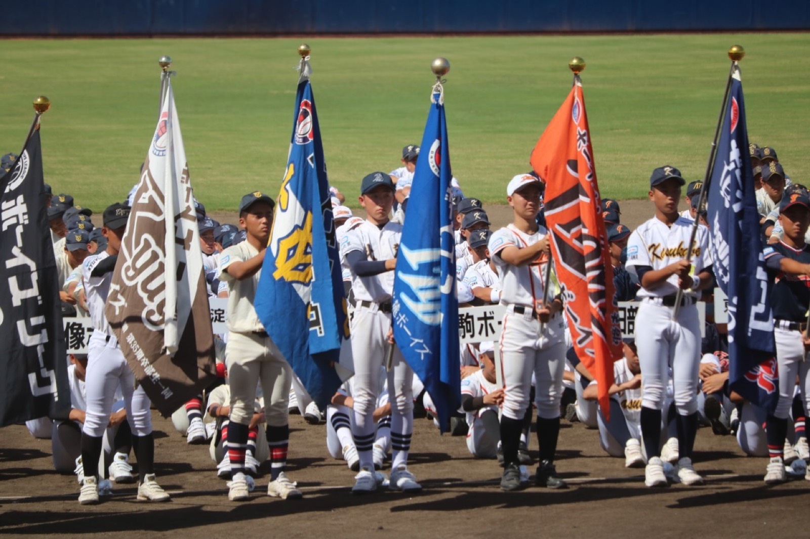開会式でチーム旗を持つ選手たち